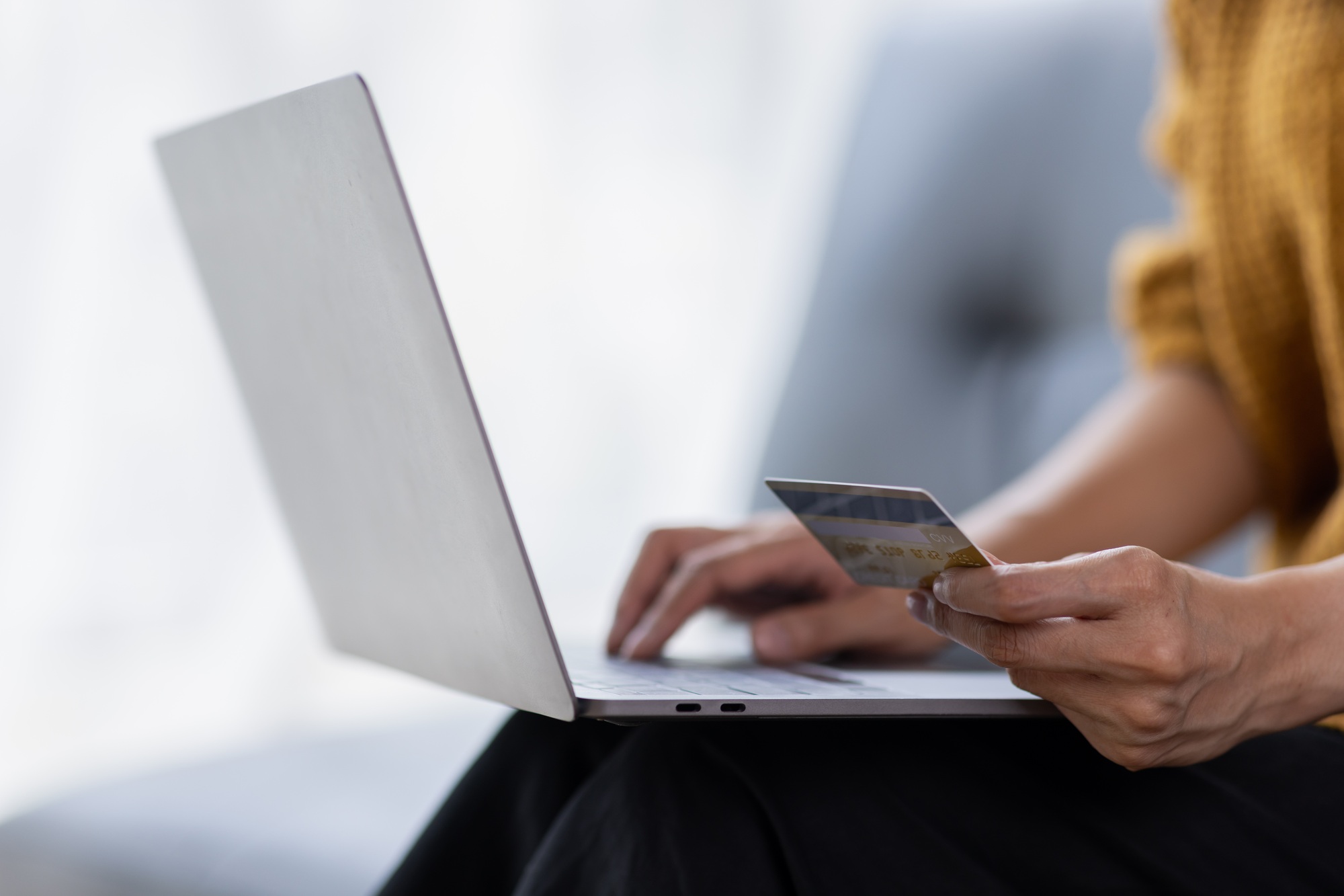 Shopper holding a credit card while making an online purchase on a laptop—secure checkout experience built by W3Inventor
