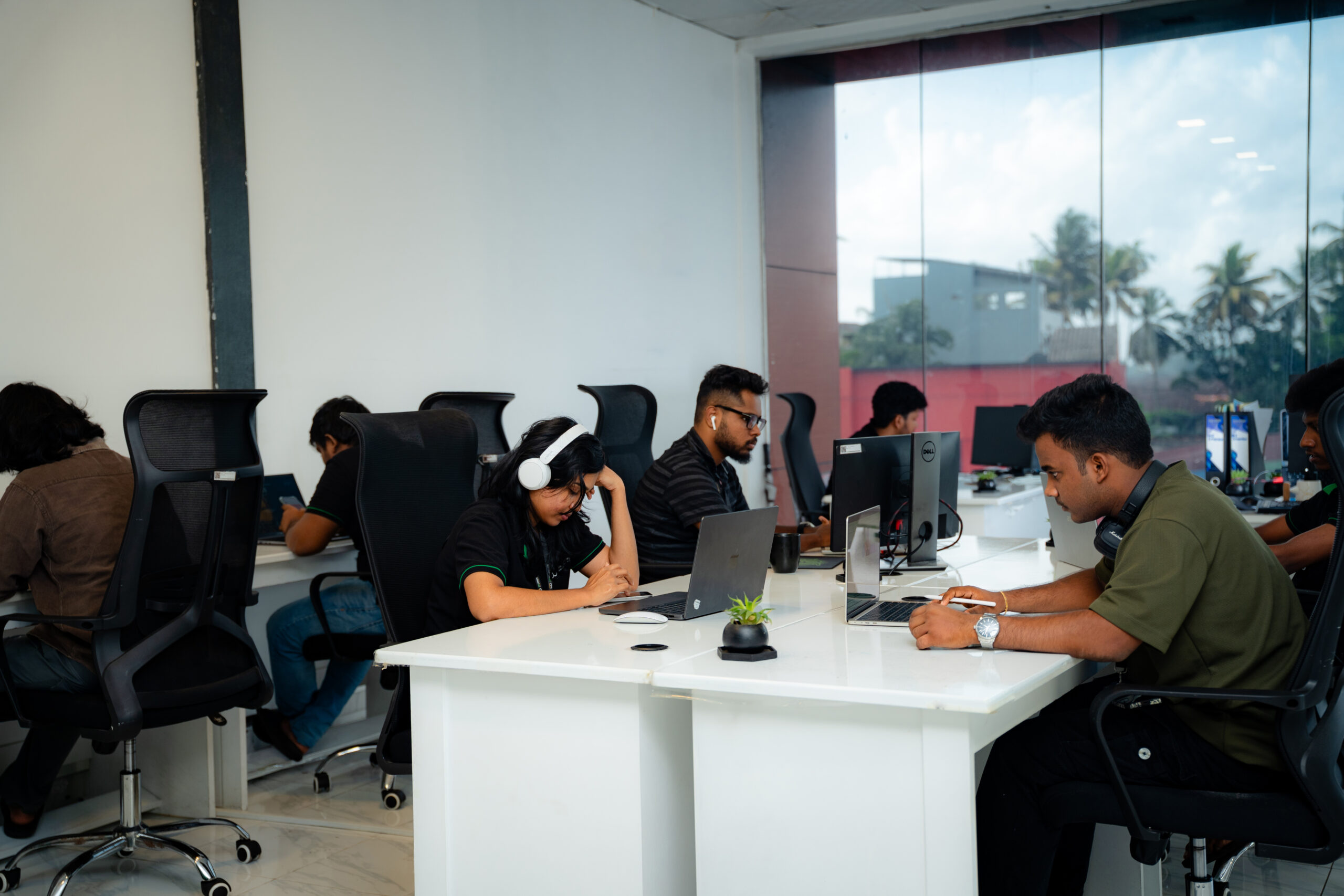 Open-plan W3Inventor workspace with teammates coding, designing and analysing data at their desks